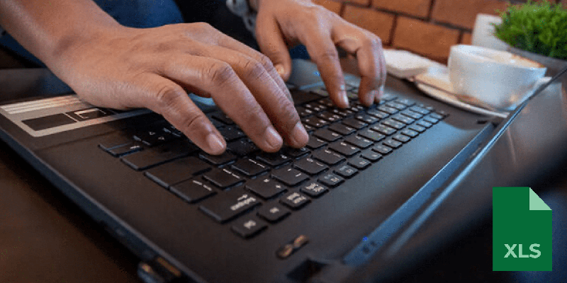 person's hands typing on a laptop keyboard